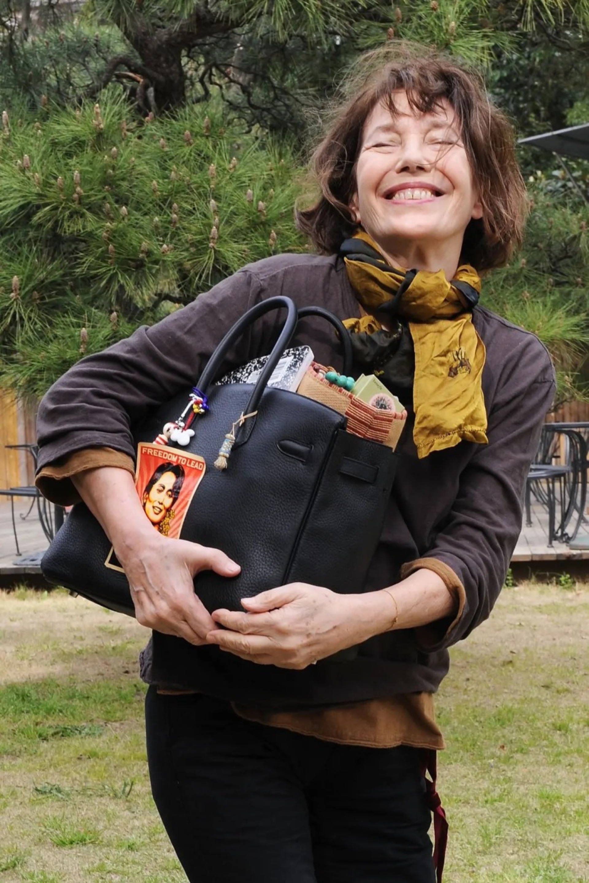 Jane Birkin with her beloved bag, tags, clippers et al | Image courtesy of Getty Images