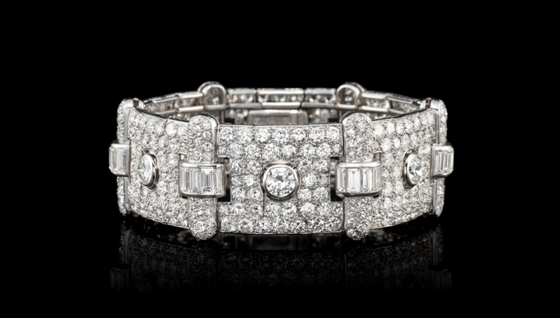 NEW YEARS WORTHY: Art Deco platinum bracelet formed of six rectangular articulated plates entirely paved with intermediate-cut diamonds linked by bridges set with baguette-cut diamonds.