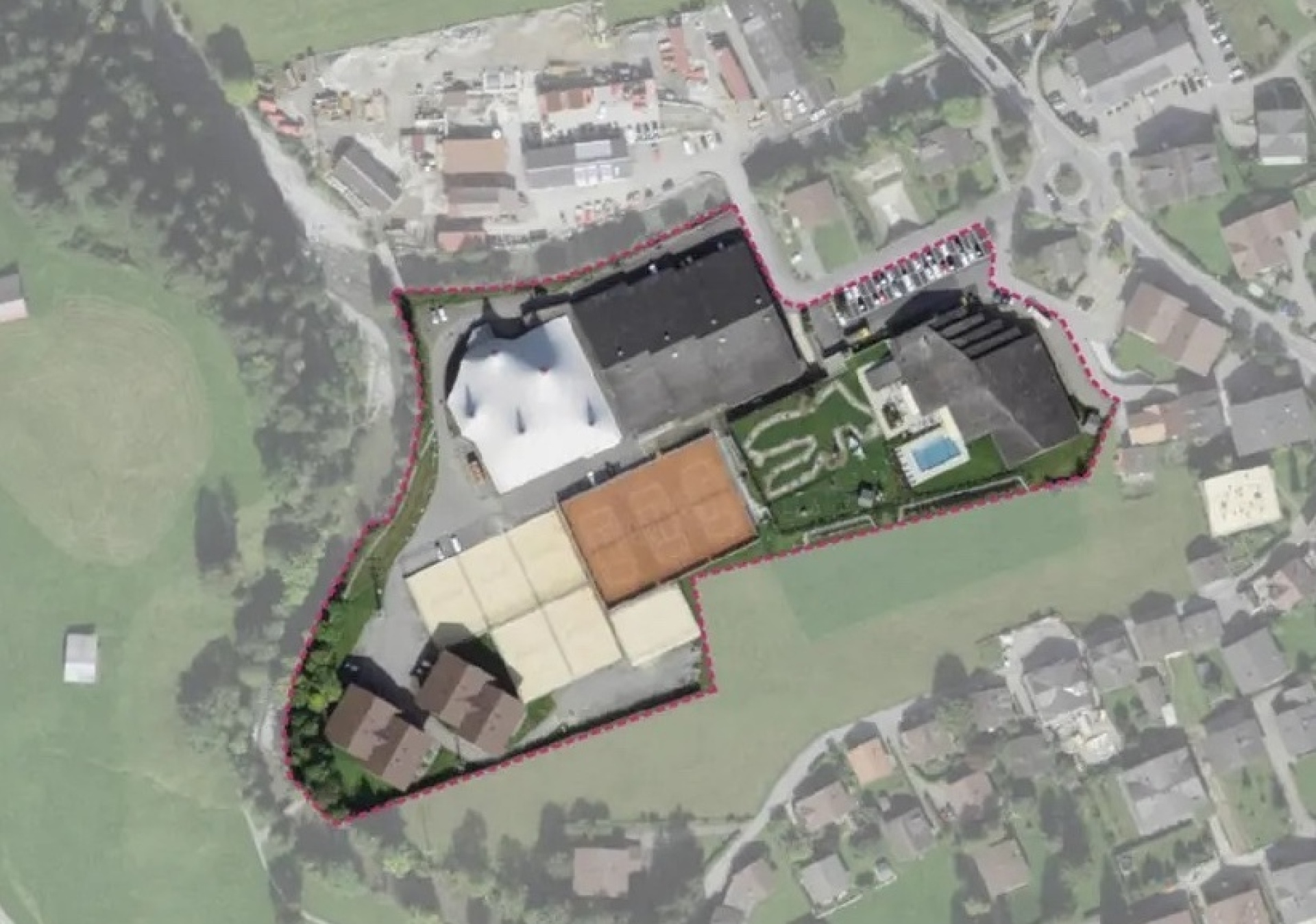The red outline shows the perimeter of the site. It is currently occupied by multi-purpose buildings and premises for sport and leisure as well as temporary cultural buildings. The white tent shape is clearly recognisable.