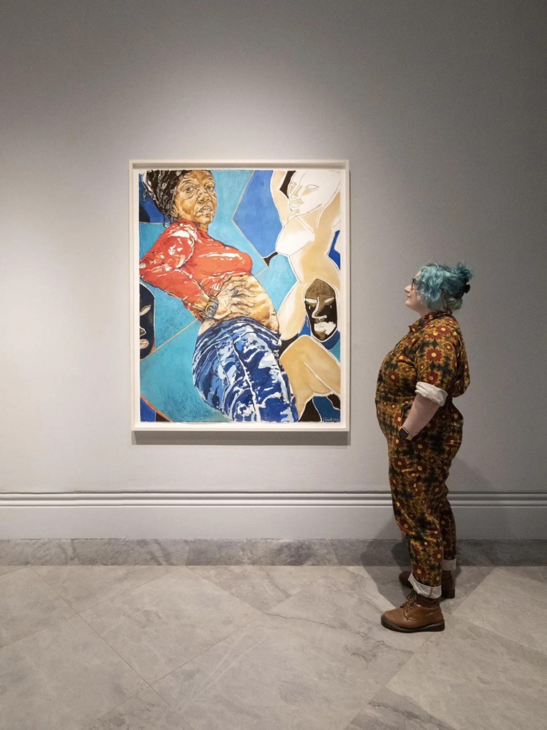 A visitor to The Time is Always Now: Artists Reframe the Black Figure at the National Portrait Gallery looks at Standing Figure with African Masks (2018) by Claudette Johnson © Photo National Portrait Gallery, London.