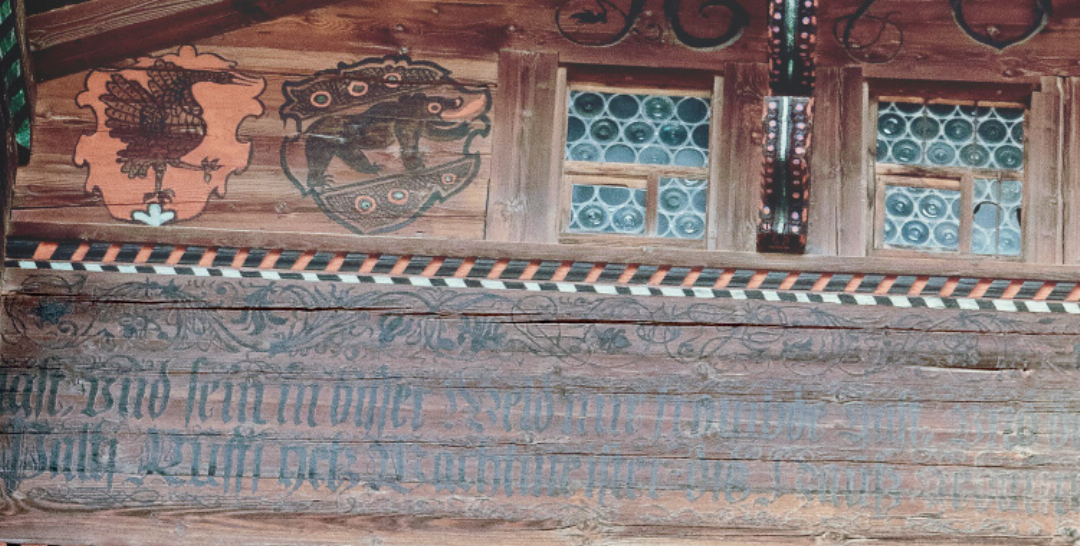 3 Still uncommon at the time, the gable features both the Bernese bear and the crane coat of arms. Saanen offered subsidies for such heraldic decorations, perhaps explaining the double display. The ornate painted inscription is written in Fraktur, a decorative script that first appeared on Tüller 3 Still uncommon at the time, the gable features both the Bernese bear and the crane coat of arms. Saanen offered subsidies for such heraldic decorations, perhaps explaining the double display. The ornate painted inscription is written in Fraktur, a decorative script that first appeared on Tüller